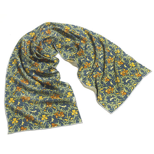 A scarf featuring golden Irises on a dark blue background after a William Morris floral pattern. William Morris was a leading member of the Arts & Crafts movement. Printed Silk Hand rolled hems Dimensions: 150cm x 35cm